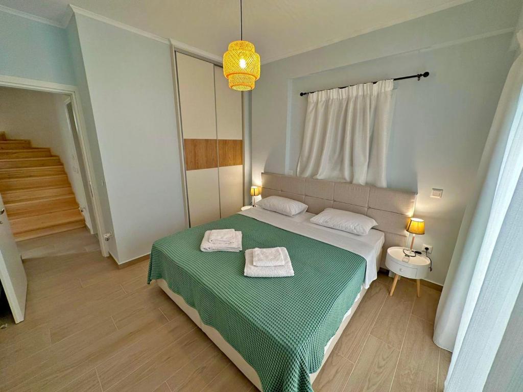 een slaapkamer met een bed met twee handdoeken erop bij Maison Rivière in Lefkada