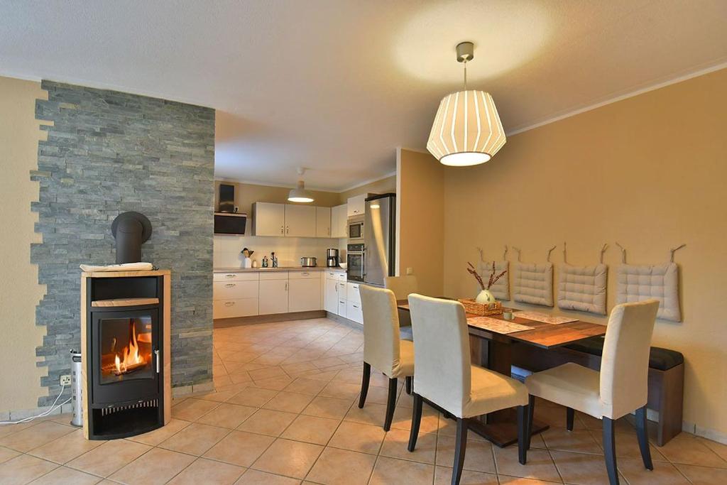 a dining room with a table and a fireplace at Ferienwohnung Etzelbach in Etzelbach