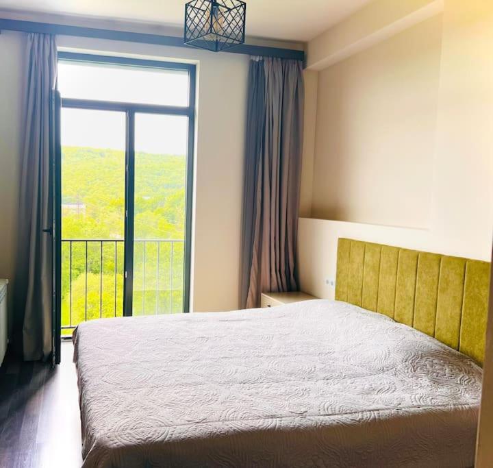 a bedroom with a large bed and a large window at Kechi House Retreat in Tsaghkadzor in Tsaghkadzor