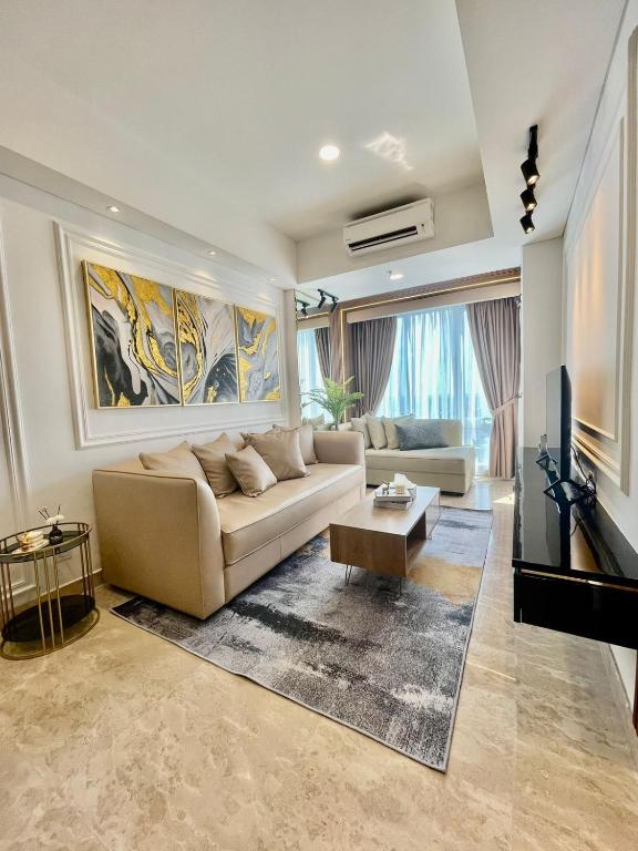 a living room with a couch and a tv at Insta-worthy staycation at 2BR luxury Apt - Podomoro Empire Tower in Medan