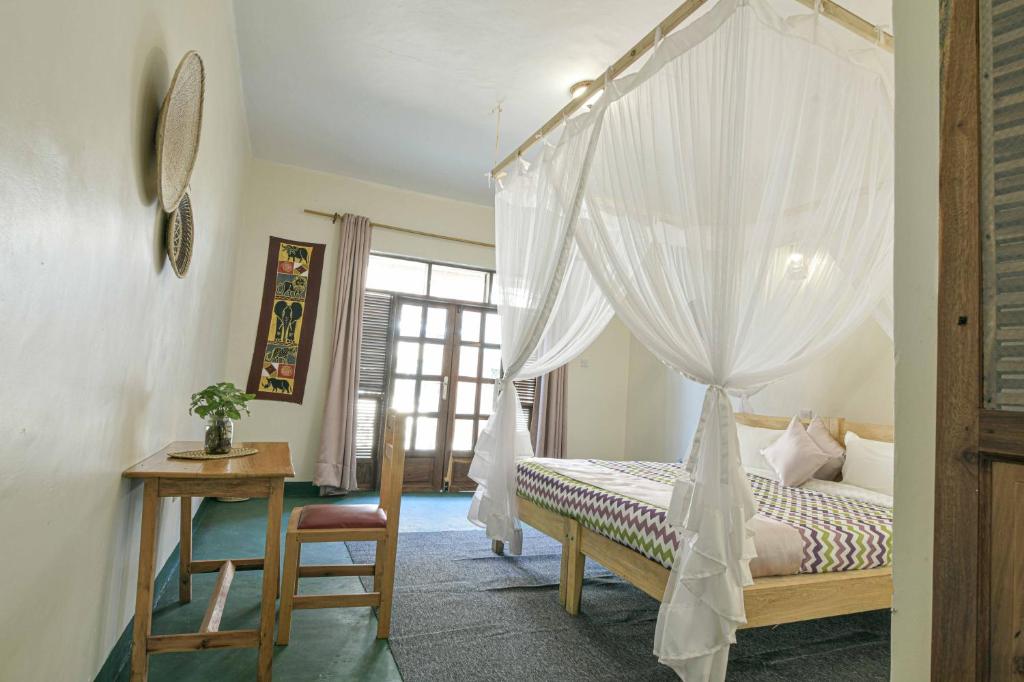 Postel nebo postele na pokoji v ubytování Cycad Entebbe Guest House