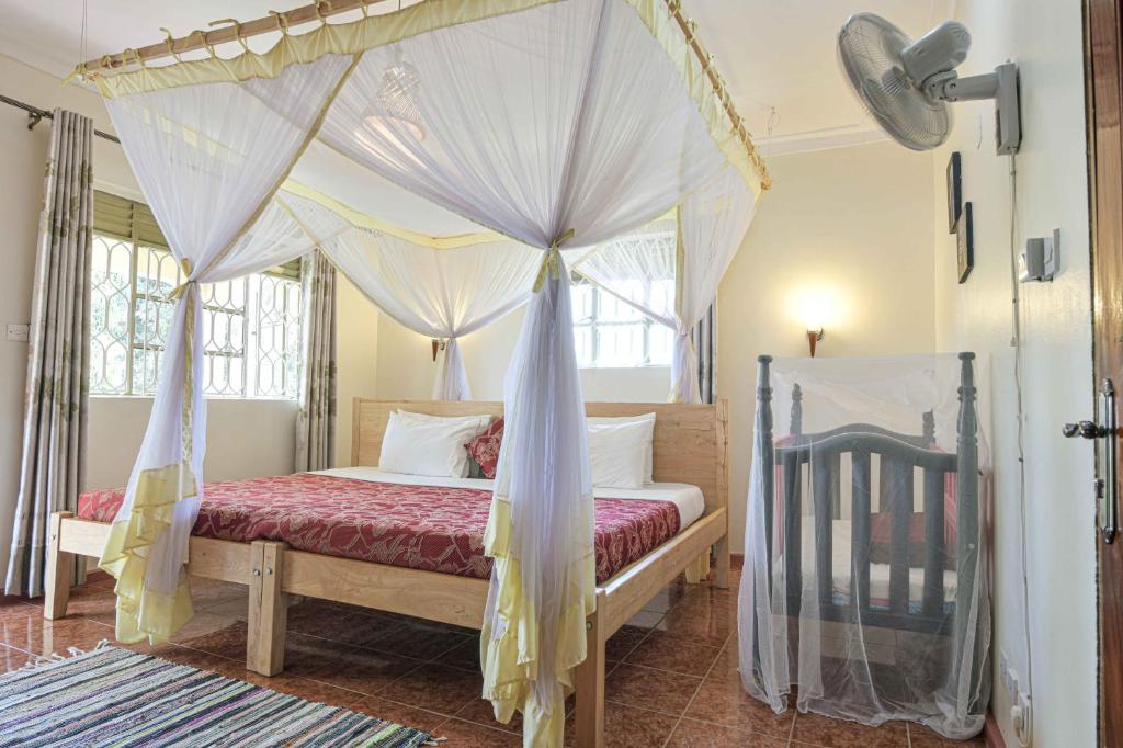 Postel nebo postele na pokoji v ubytování Cycad Entebbe Guest House