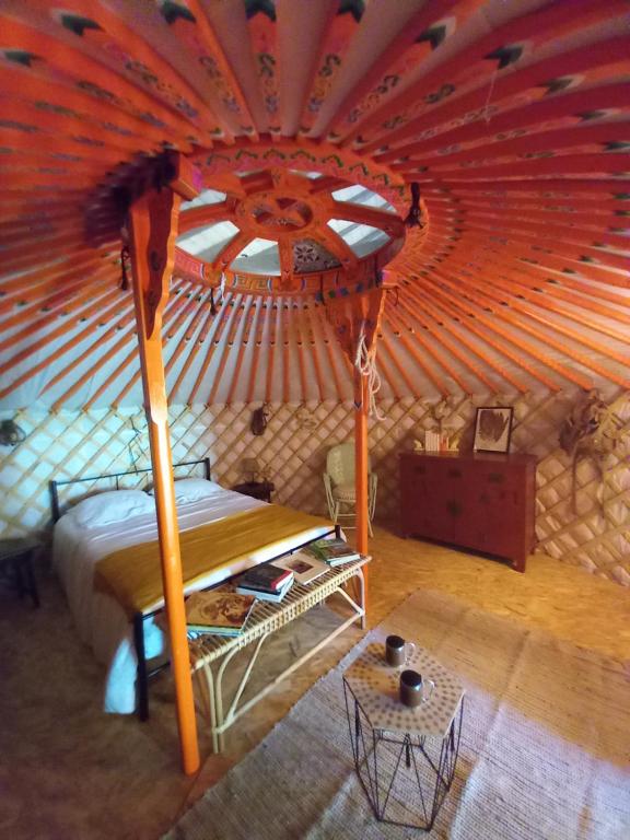 a large room with a bed in a yurt at La yourte des Merveillaux in Riocaud