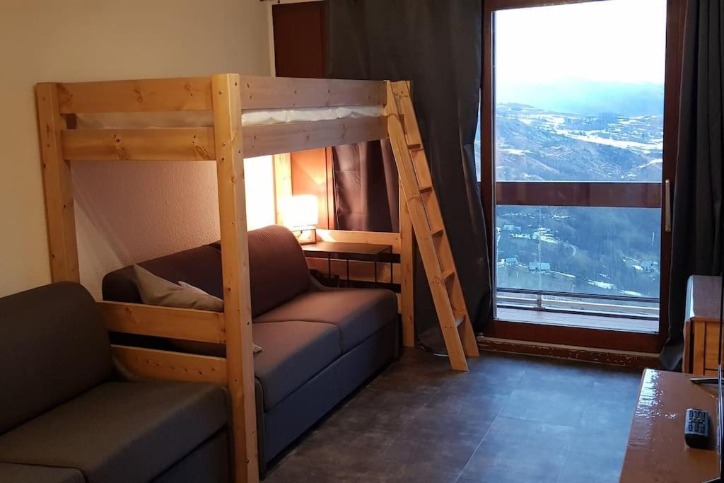 un letto a castello e un divano in una stanza con una finestra di Mes vacances à la montagne a Villarembert