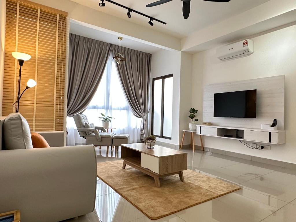 ein Wohnzimmer mit einem Sofa und einem TV in der Unterkunft Bali Residence Melaka near Jonker Street in Malakka