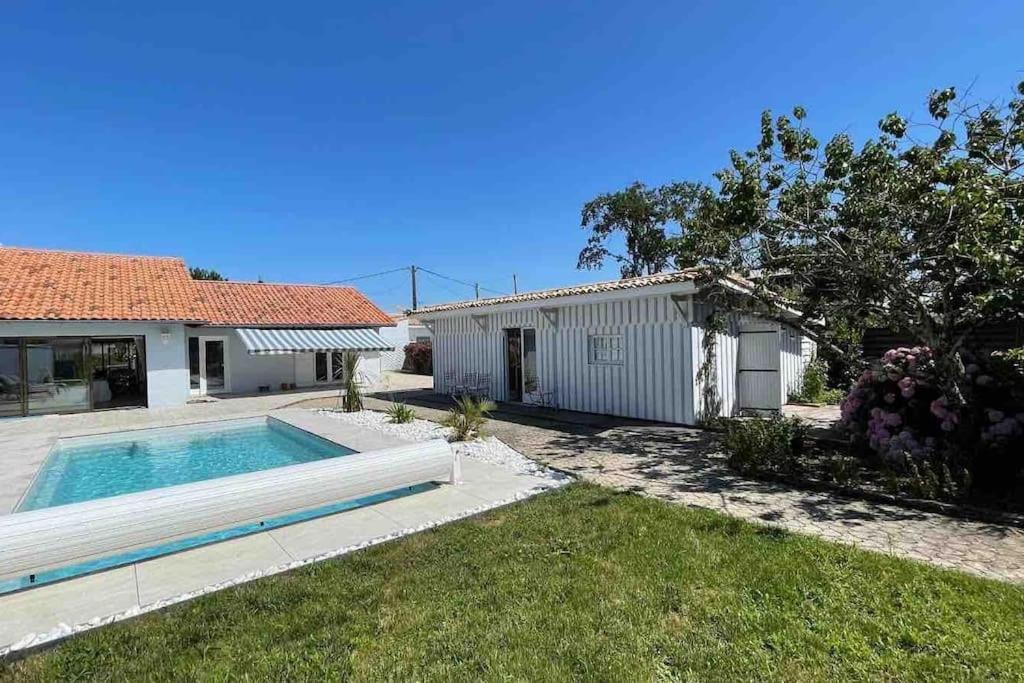 una casa con piscina en un patio en Villa Moderne + Guest House + Piscine chauffée, en Gujan-Mestras