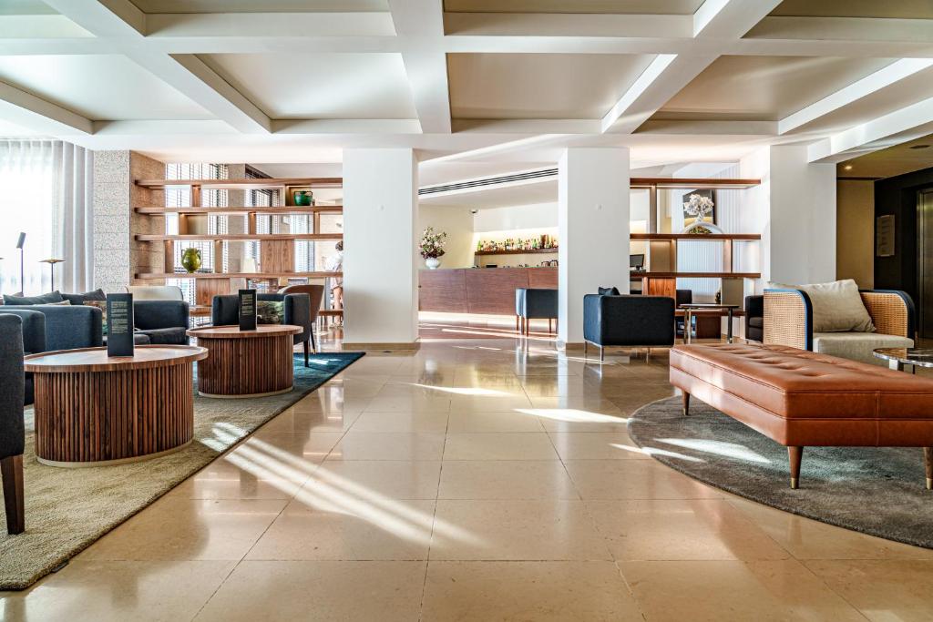 a lobby of a hotel with tables and chairs at Hotel Dom Goncalo & Spa in Fátima