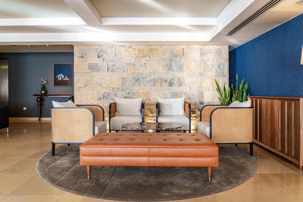 a lobby with an orange ottoman and chairs at Hotel Dom Goncalo & Spa in Fátima
