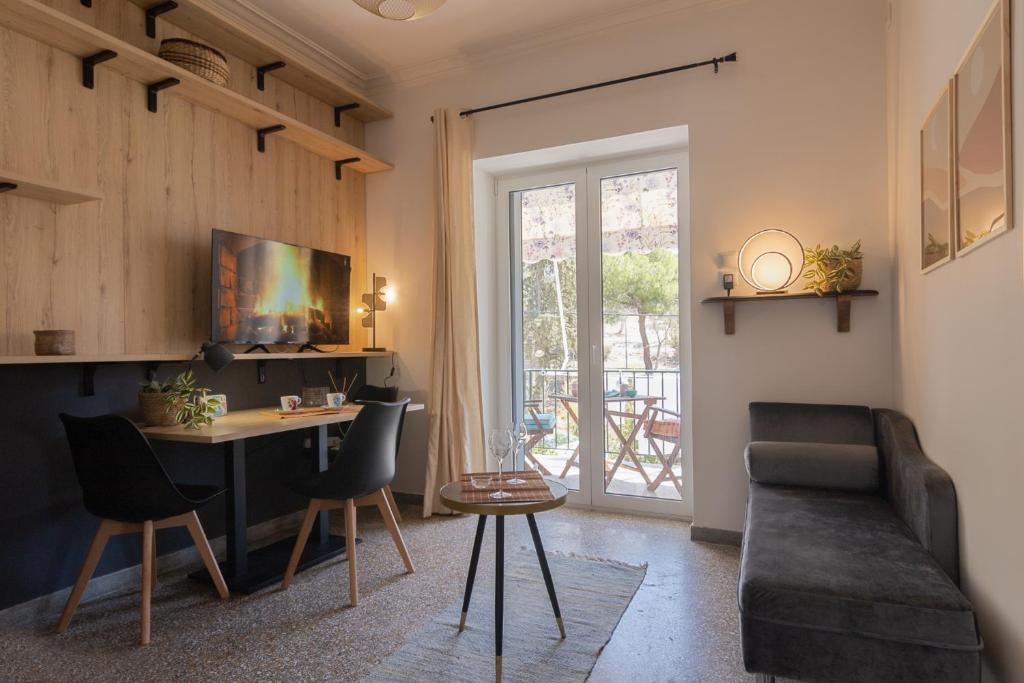 sala de estar con mesa, sillas y sofá en Vivid Stays Petralona, en Atenas