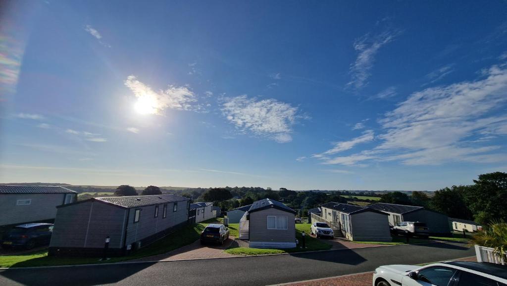 a residential neighborhood with houses and the sun in the sky at Roecliff in St Austell