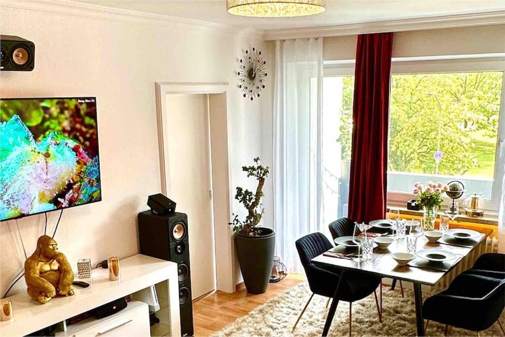 ein Wohnzimmer mit einem Tisch mit Stühlen und einem TV in der Unterkunft Premium Wohnung in Bestlage! in München
