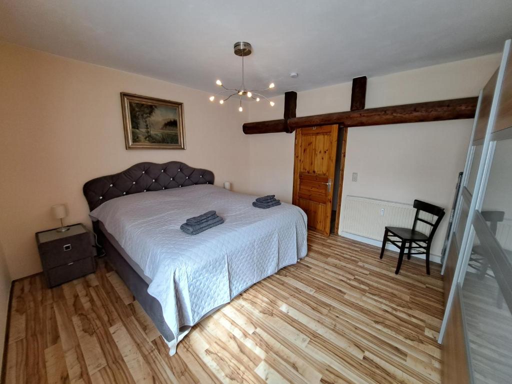 a bedroom with a bed and a chair in it at Gesindewohnungen Schloss Hilbringen in Merzig