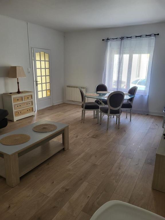 a living room with a table and chairs at Maison calme proche de la rivière in Teillé