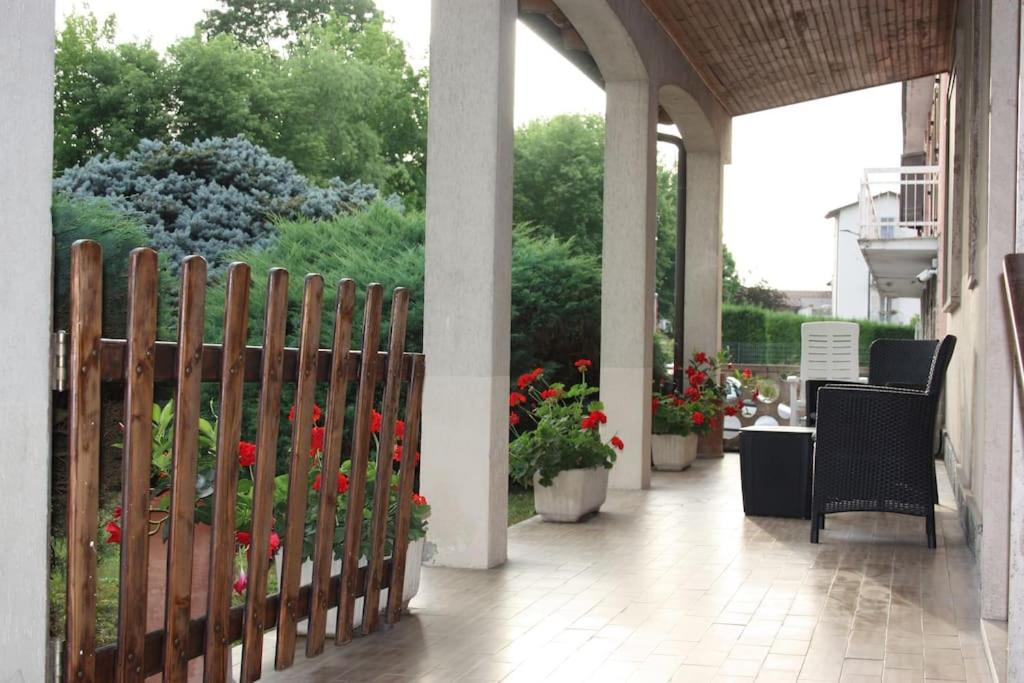 un porche con una valla de madera y flores en Casa tra le vigne, en Mombercelli