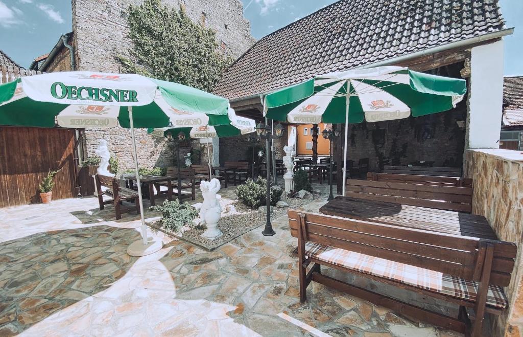 a patio with a bench and two umbrellas at Hotel Schwarzach am Main in Schwarzach am Main