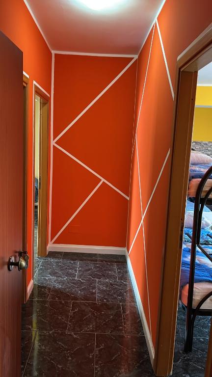 un pasillo con una pared de color naranja y una puerta en B&B Nonna Viola, en Palizzi Marina