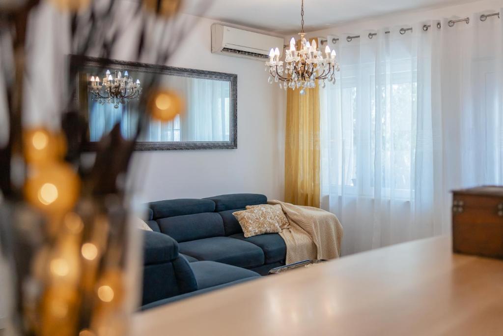 salon z niebieską kanapą i lustrem w obiekcie Apartment Tree Of Life w mieście Kaštela