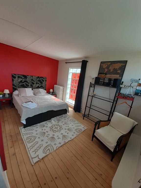 um quarto com uma cama grande e uma cadeira em Chambre d'hôte près de Paris em Épinay-sur-Seine