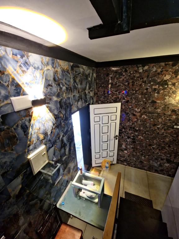 Pokój z kamienną ścianą z drzwiami w obiekcie Rock Lake Villa w mieście Vagamon