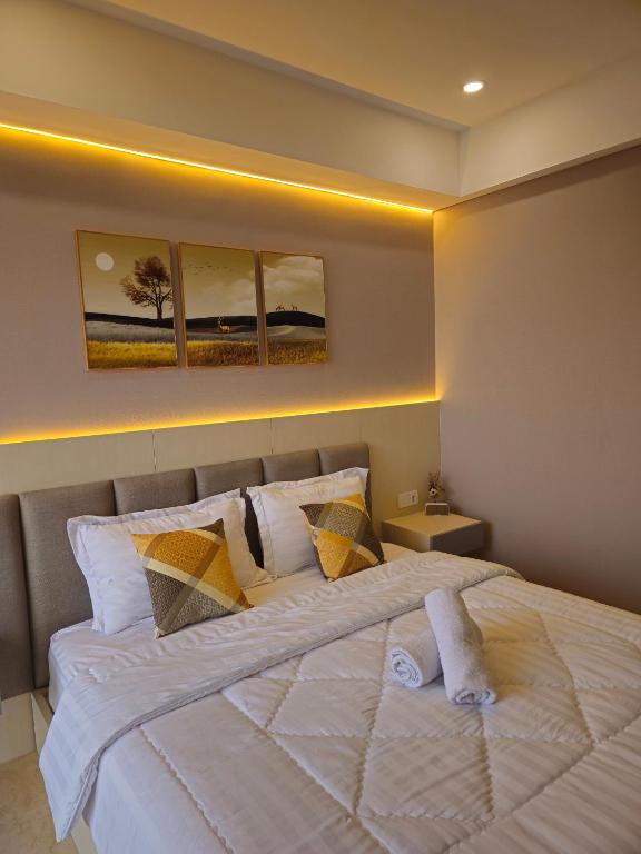 a bedroom with a large white bed with pillows at Studio Apartment at Gold Coast PIK in Jakarta