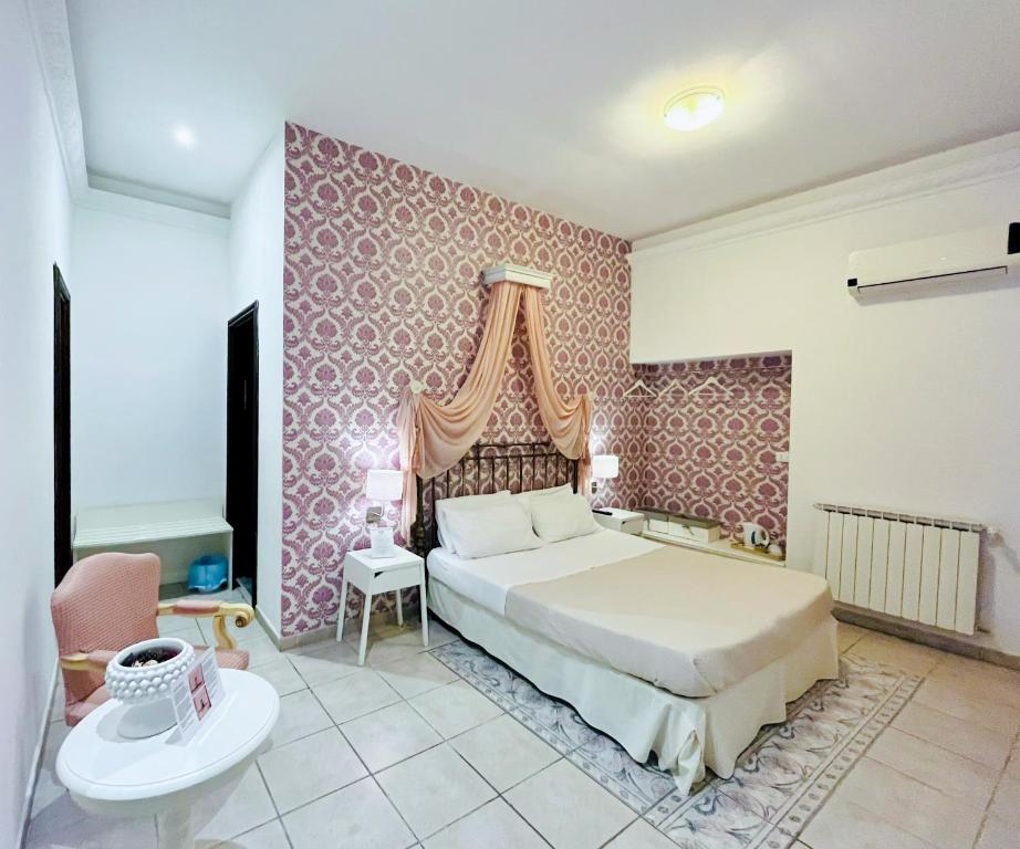 una camera con letto e parete rosa di Antica Palermo B&B a Palermo