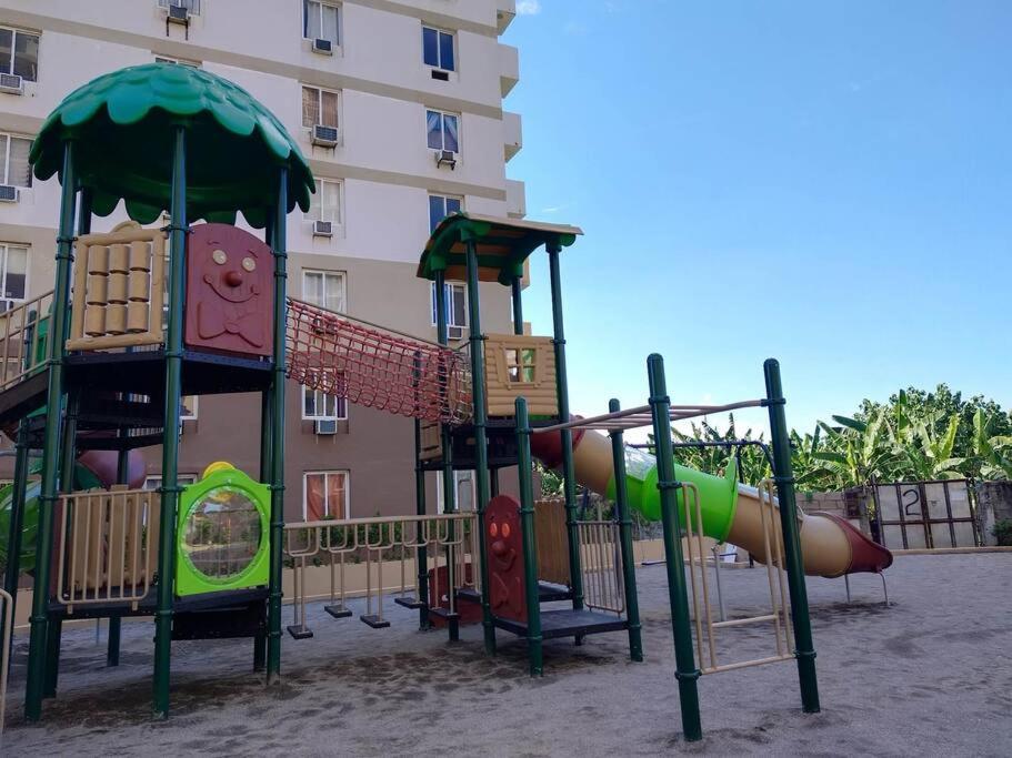 a playground with a slide in front of a building at Ohana Suites Lapu-Lapu City Condo Staycation Near Mactan International Airport in Lapu Lapu City