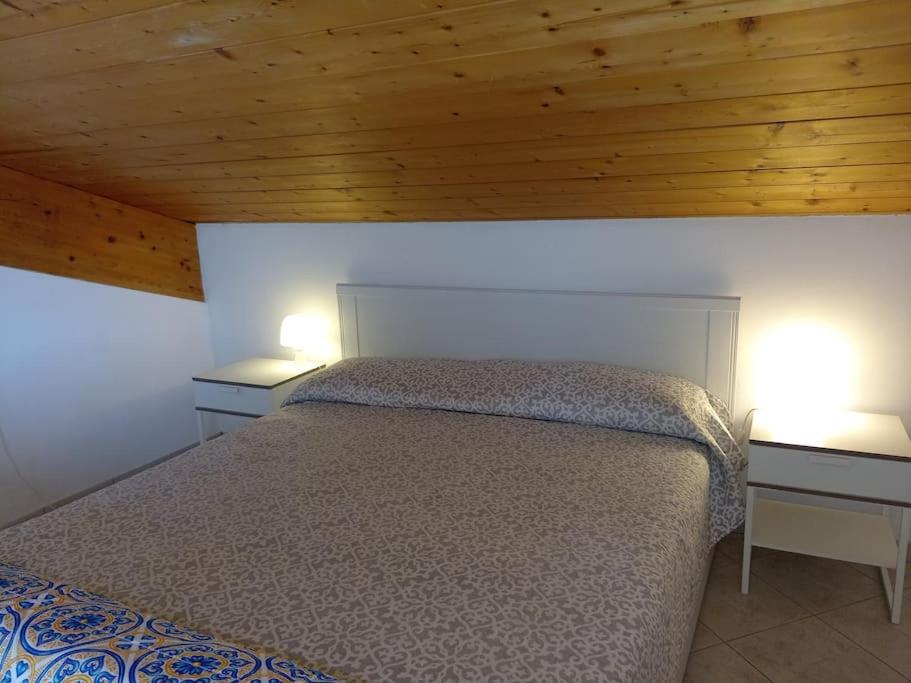 una camera con un letto e due comodini con due lampade di Accogliente appartamento mansardato vicino al mare a Tortoreto