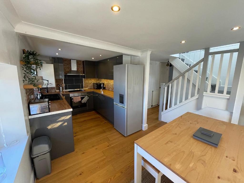 a large kitchen with a table and a refrigerator at Stylish 2 bedroom apartment close to beaches in Fakenham