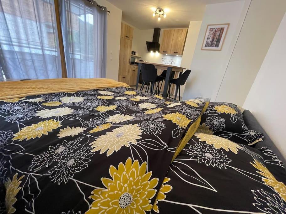 ein Schlafzimmer mit einem Bett mit einer schwarzen und gelben Decke in der Unterkunft studio 3 *** centre village Saint-Jean-de-Sixt in Saint-Jean-de-Sixt