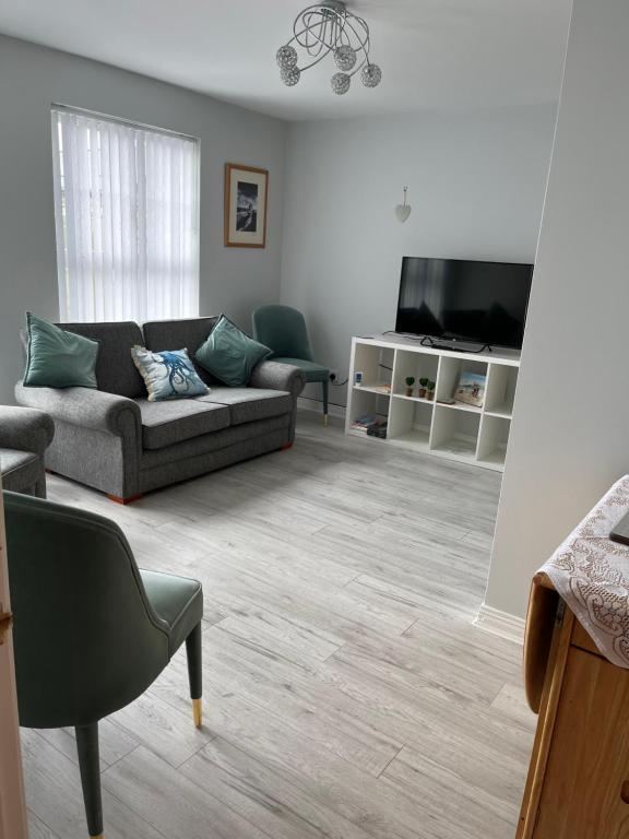 a living room with a couch and a flat screen tv at Garden Avenue in Portstewart