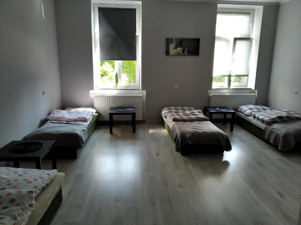 Habitación con 3 camas y 2 ventanas en Pokoje gościnne w centrum en Wałbrzych