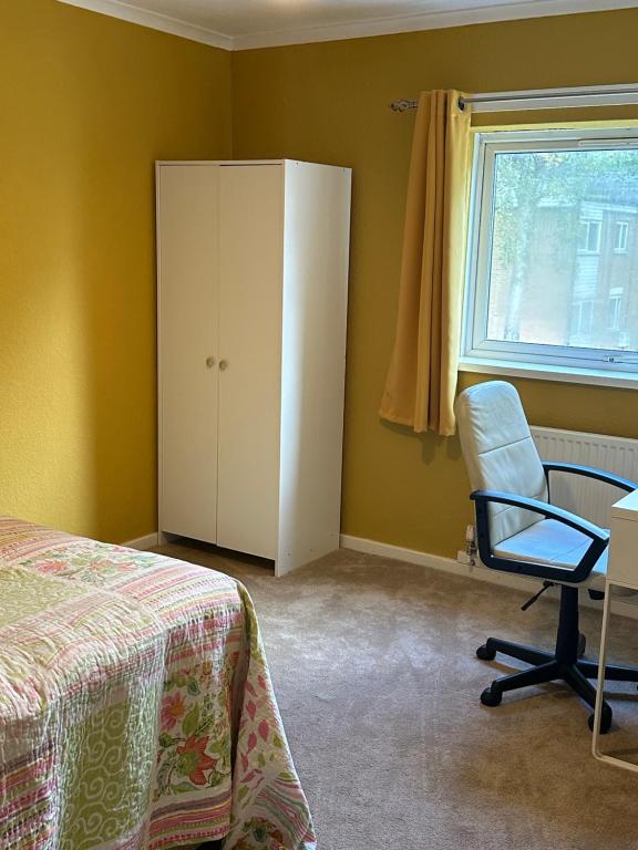 een slaapkamer met een bed, een stoel en een raam bij Double Room Rent in Birmingham