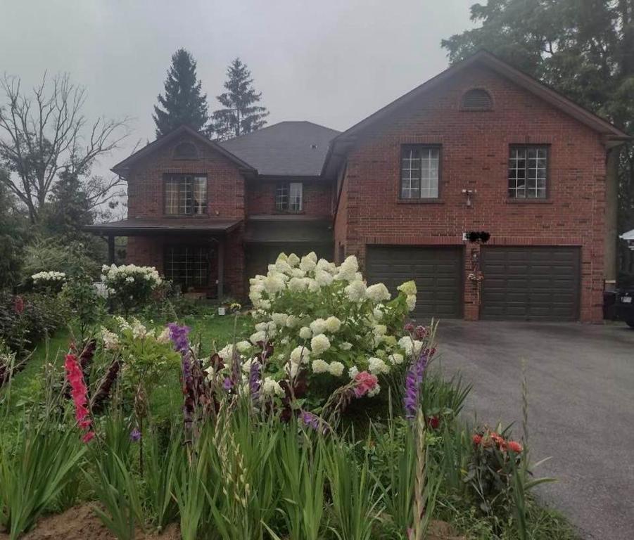 a house with a bunch of flowers in front of it at Luxury Suites at Military Trail in Toronto