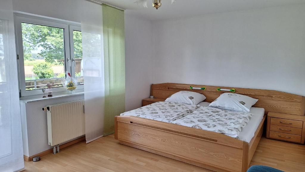 - une chambre avec un lit en bois et une fenêtre dans l'établissement Ferienwohnung Schwanau Nähe Europapark, à Schwanau
