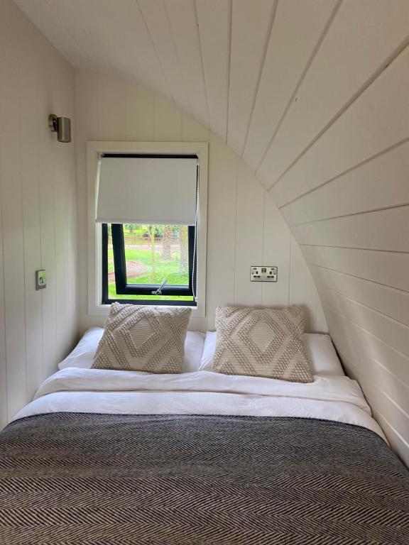 a bed in a small room with a window at Kildare countryside pods in Kildare