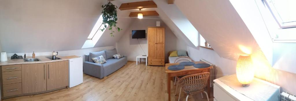 a kitchen and a living room with a couch and a table at Apartament Stary Rynek in Stary Sącz