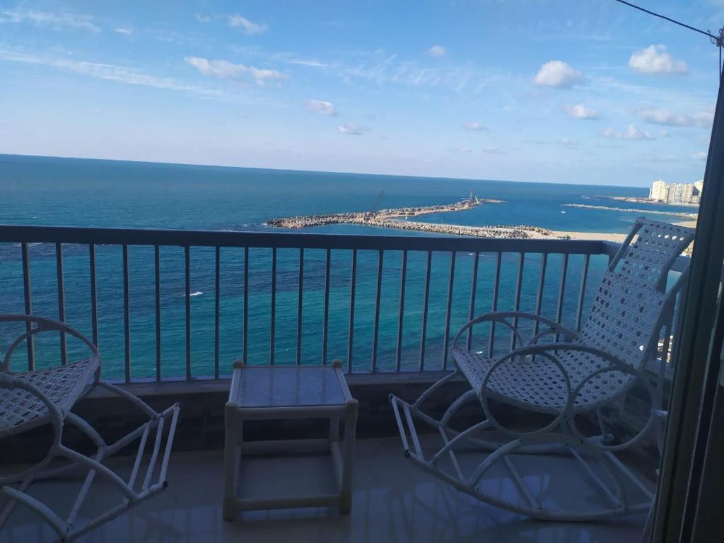 Un balcón con sillas y vistas al océano. en شقة فاخرة علي البحر مباشرة لوران الاسكندرية en Alexandría