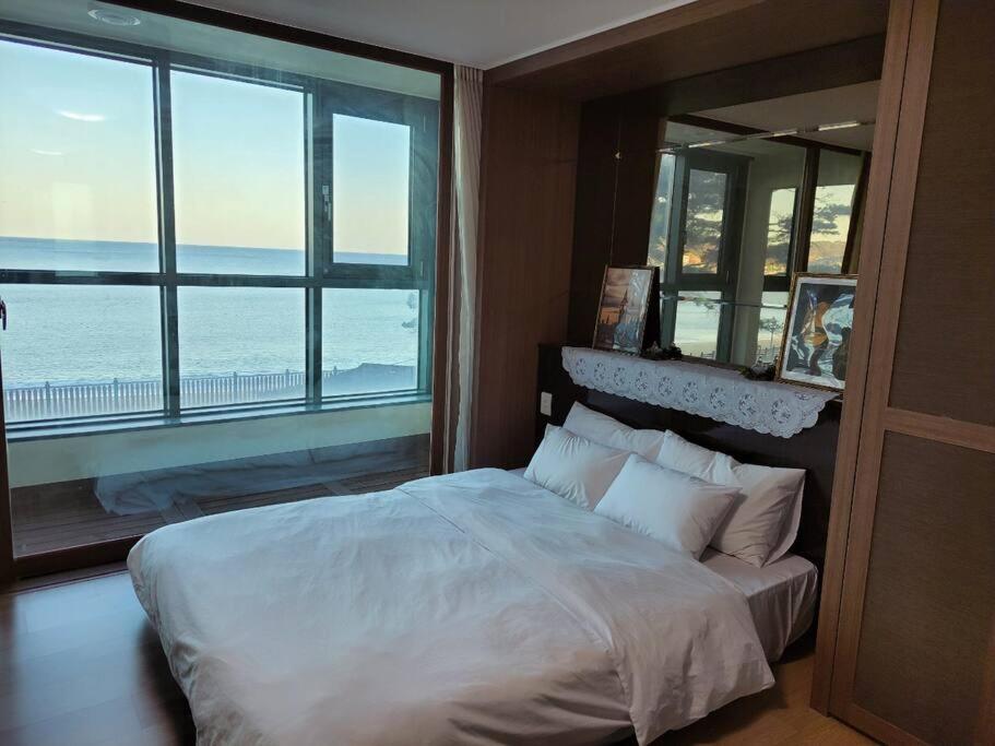 um quarto com uma cama e vista para o oceano em Ocean & sunrise View-10 seconds of beach walk - Three bedrooms em Goseong