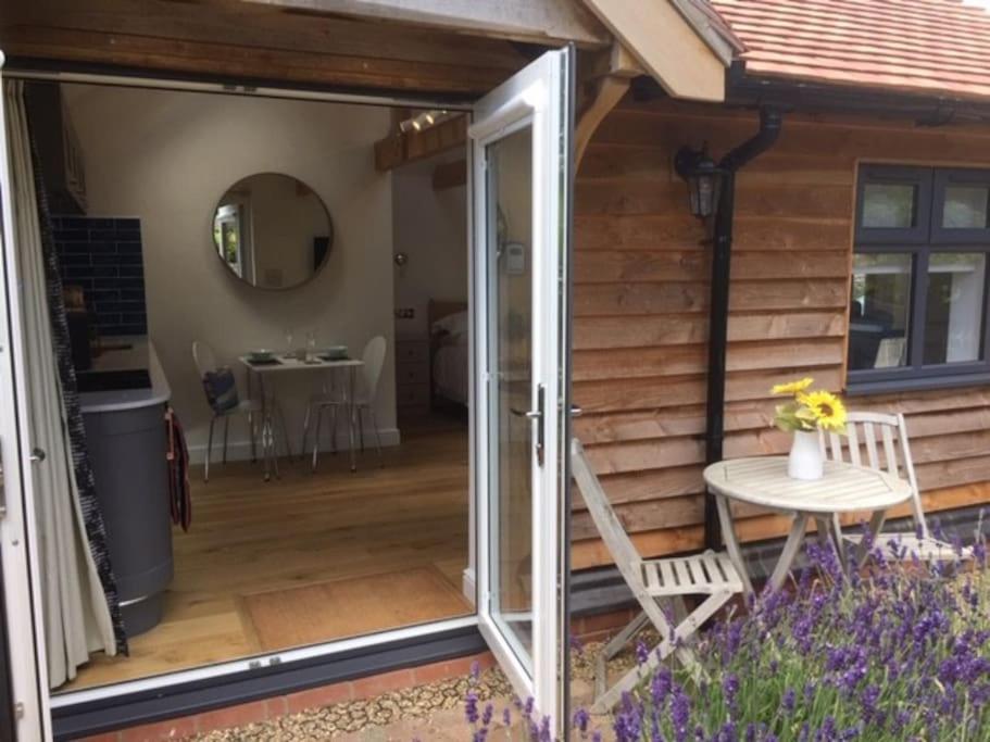 an open door to a patio with a table and a chair at Cliff Lane Annexe: stylish in a perfect location. in Cromer