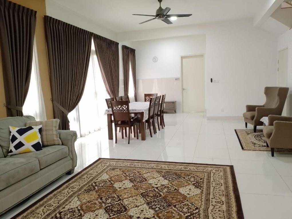 a living room with a couch and a table and chairs at Pinevalley Homestay Putrajaya Presint 12 in Putrajaya