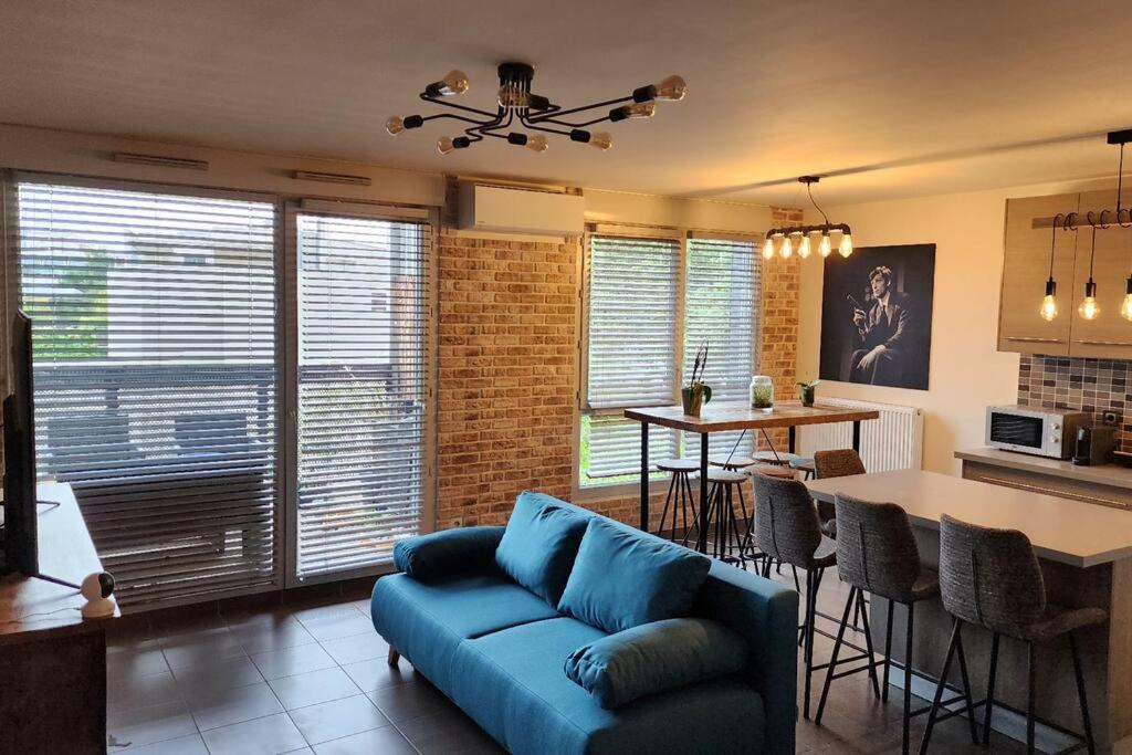 Il comprend un salon avec un canapé bleu et une cuisine. dans l'établissement Appartement Voie Lactée Lyon, à Lyon