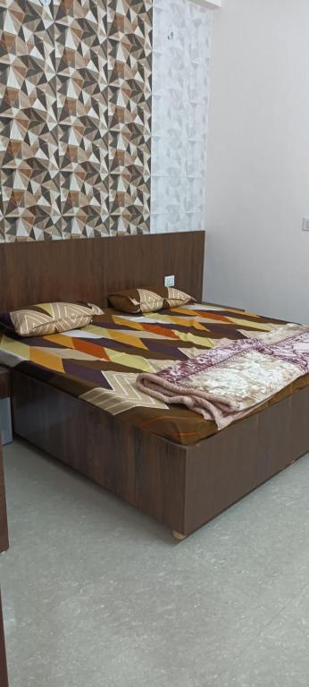 a bed with a wooden frame in a room at Shree shyam kunj Home stay in Mathura