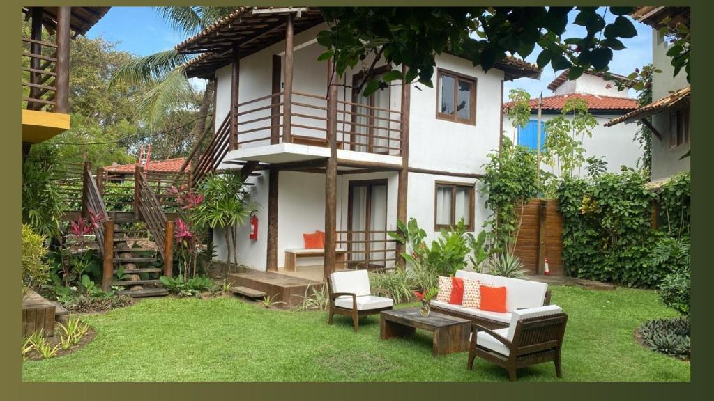 ein Haus mit einem Garten mit Stühlen und einem Tisch in der Unterkunft Pousada Bambu Dourado in Marau