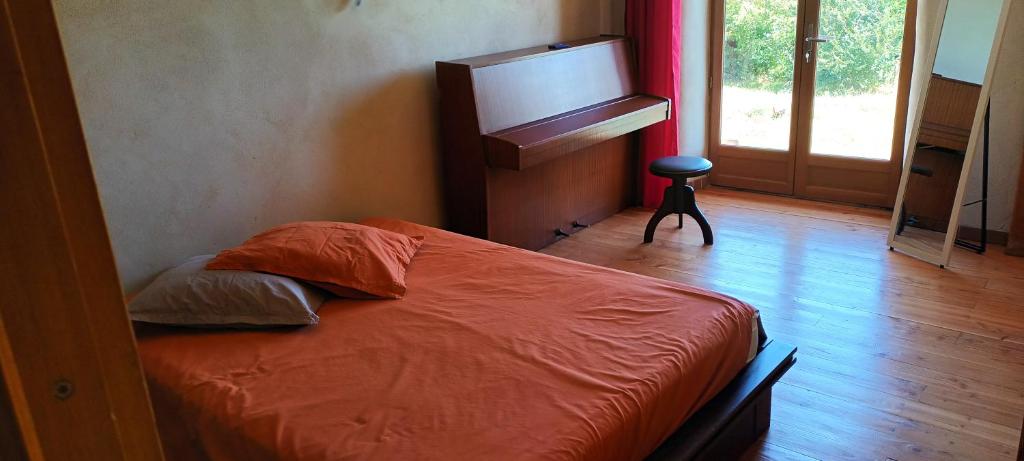 1 dormitorio con 1 cama con edredón de naranja en Lâche prise en Les Mages