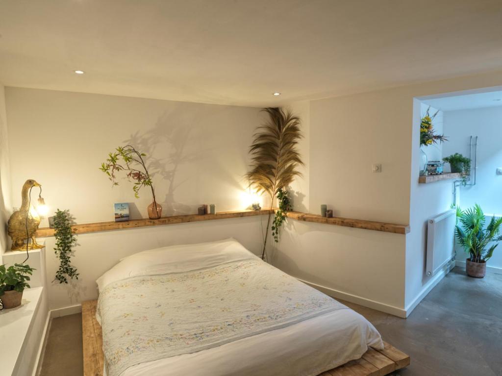 a bedroom with a bed with plants on the wall at Tiny Beachhouse in Scheveningen