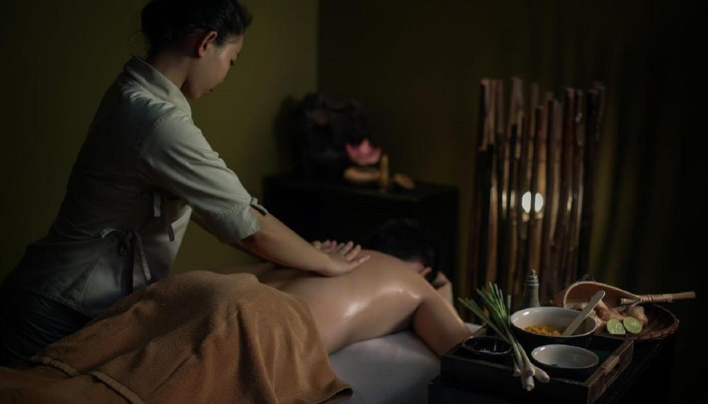 a woman sitting on a bed with a man sitting on a bed at Sala Siem Reap Hotel in Siem Reap