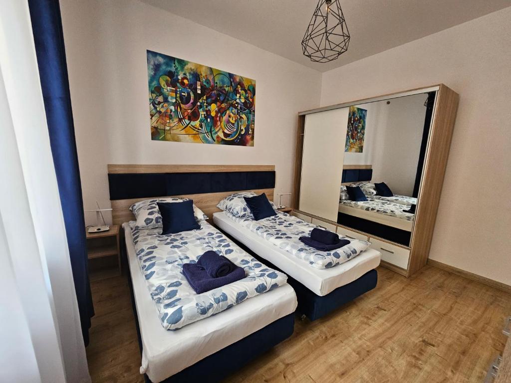 Pokój hotelowy z 2 łóżkami i lustrem w obiekcie Apartamenty KoktajLOVE w Kielcach