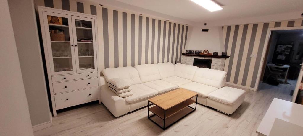 a living room with a white couch and a table at Mieszkanie przy rzece in Gołdap