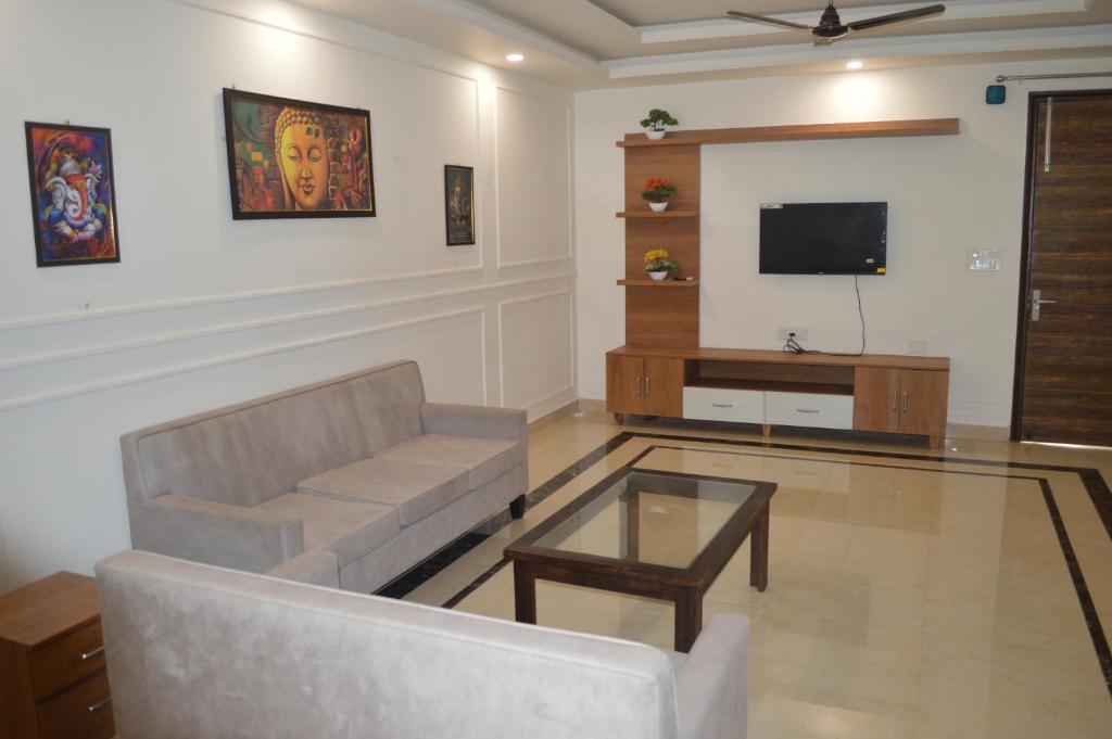sala de estar con sofá y TV en Aarya Rishikesh - Luxurious 2 BHK, en Rishīkesh