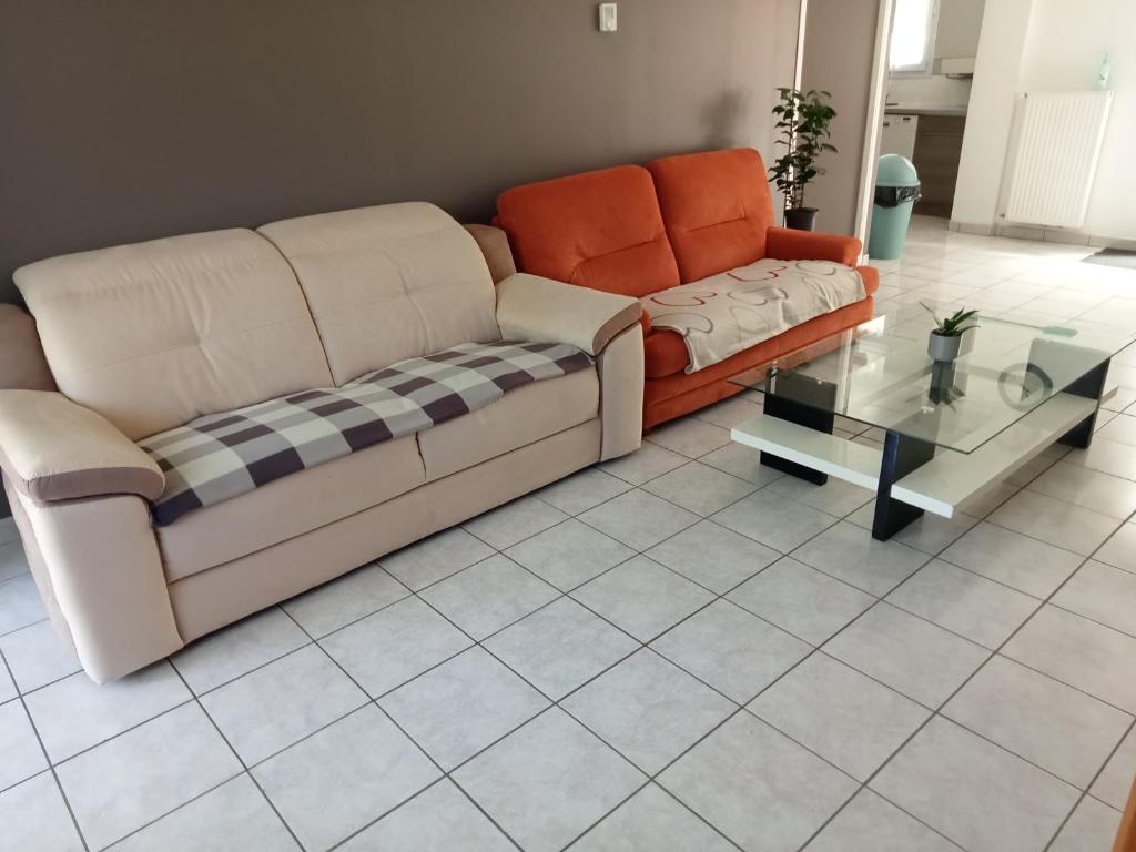 a living room with a couch and a glass table at Location de vacances avec terrasse pour 6 pers, à 2 mn des plages, centre ville et commodités in Douarnenez